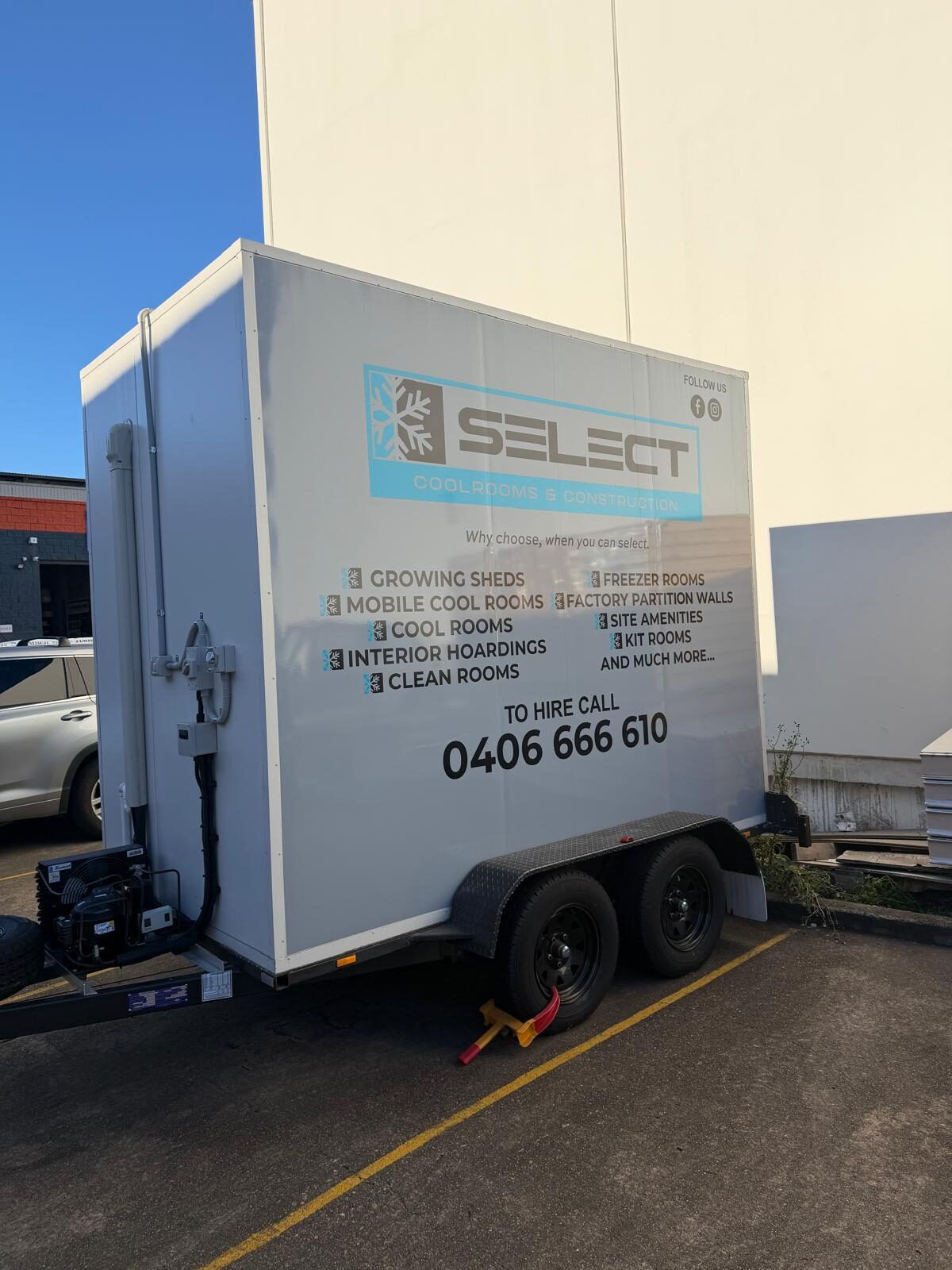 The Select Mobile Coolrooms hire trailer from a front three-quarter angle, showing its tandem-axle running gear and mounted refrigeration unit